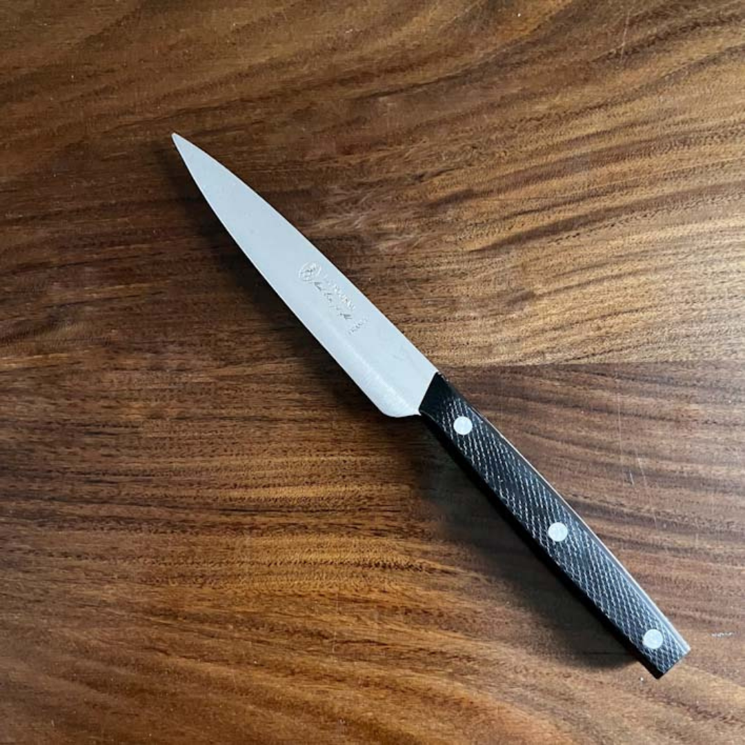 French Paring knife by La Fourmi with a black handle on a wooden surface