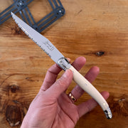 Laguiole steak knife with cream riveted handle and serrated metal blade 