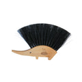 Hedgehog-shaped brush with black bristles on a white background