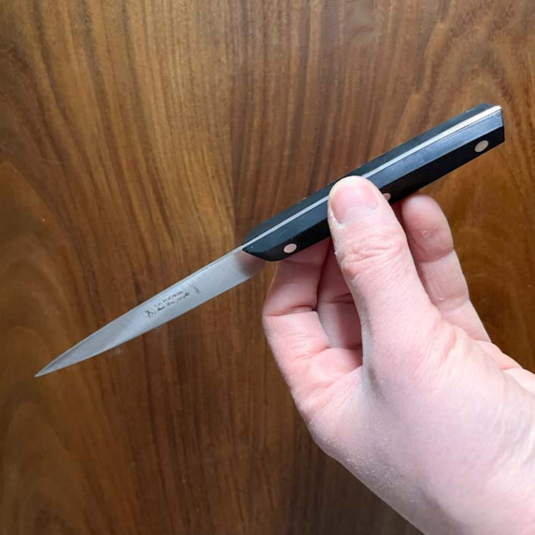 La Fourmi Paring Knife with a full tang blade and a black handle on a white background, made in France