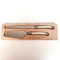A two-piece wooden serving knife set from Laguiole Jean Neron, featuring a serrated bread knife and a cake/pie server, both with cream-colored handles and polished steel blades, presented in a engraved wooden box.